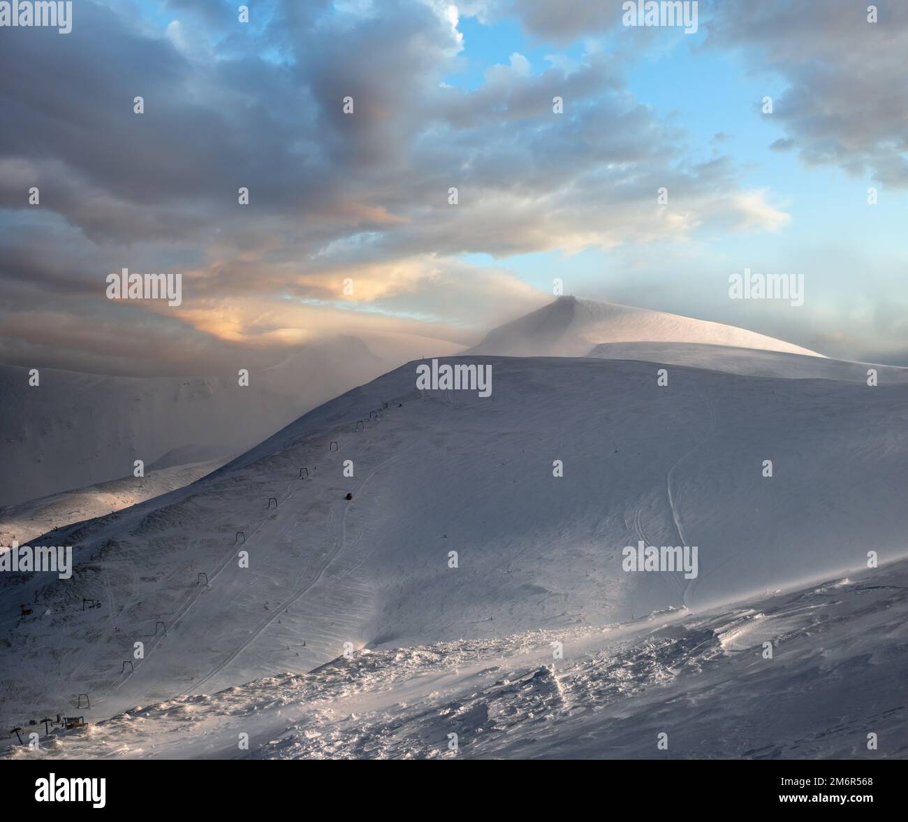 Snow covered mountain slope in last evening sunlight. Magnificent windy 