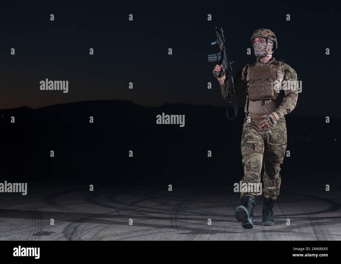 Army soldier in Combat Uniforms with an assault rifle, plate carrier