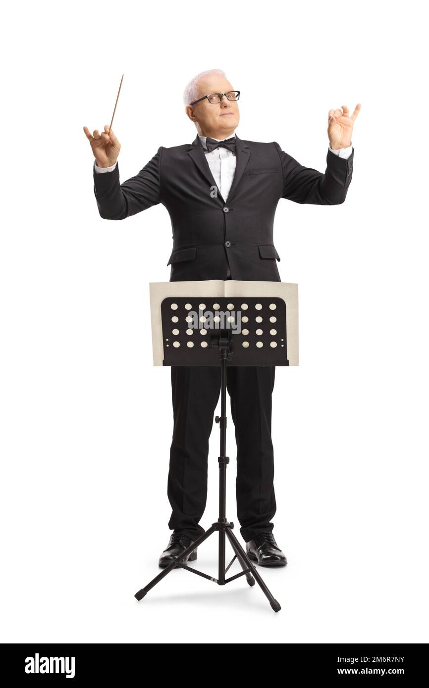 Full length portrait of a music conductor standing in front of a sheet music stand and directing a performance isolated on white background Stock Photo