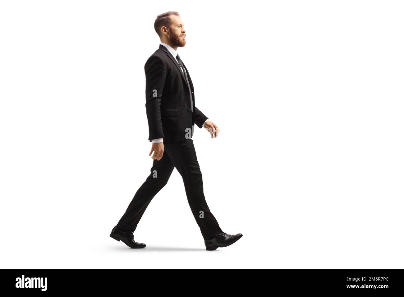 Professional man in a black suit walking isolated on white background ...