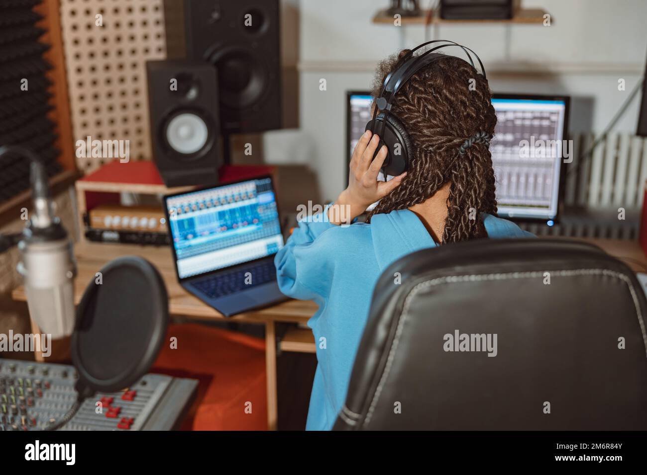 Rear view of a radio presenter, anchor woman, sound engineer wearing