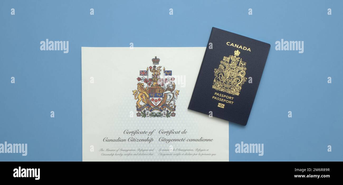 A Canadian Passport on a Canadian Citizenship Certificate against a light blue background Stock Photo
