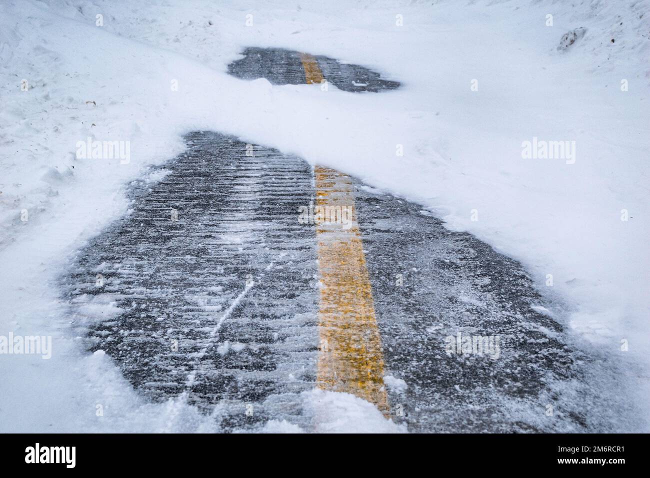 Road under the snow. Close-up of snow on the road. Impossibility of taking a vehicle. Snow storm. Transport impossible with snow. Road with snow. Stock Photo