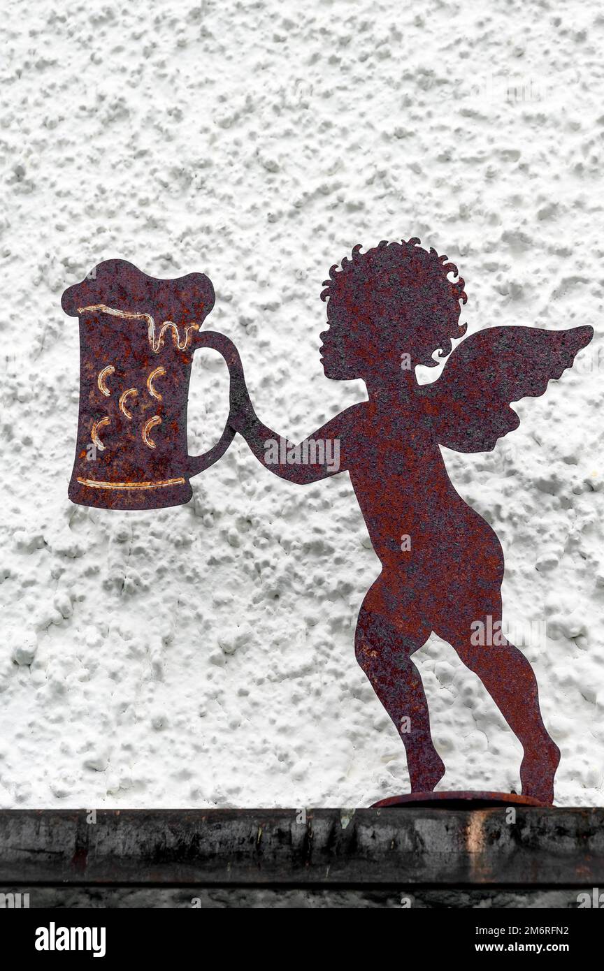 Iron rusty putto with beer stein in front of house wall, Hindelang, Allgaeu, Bavaria, Germany Stock Photo