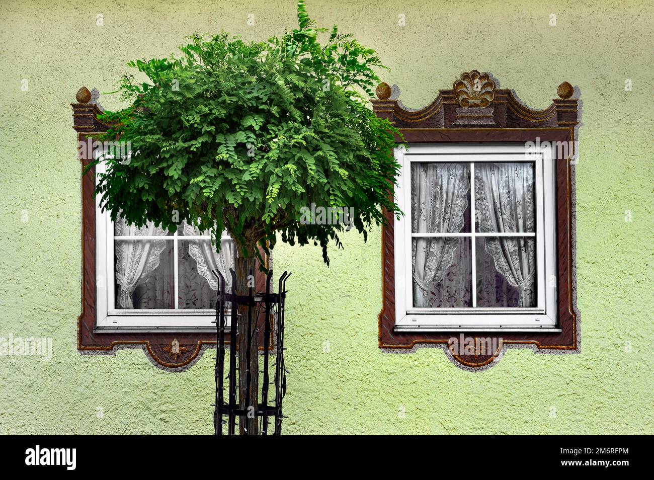 Green house wall and window with curtains and painted frames, Hindelang, Allgaeu, Bavaria, Germany Stock Photo