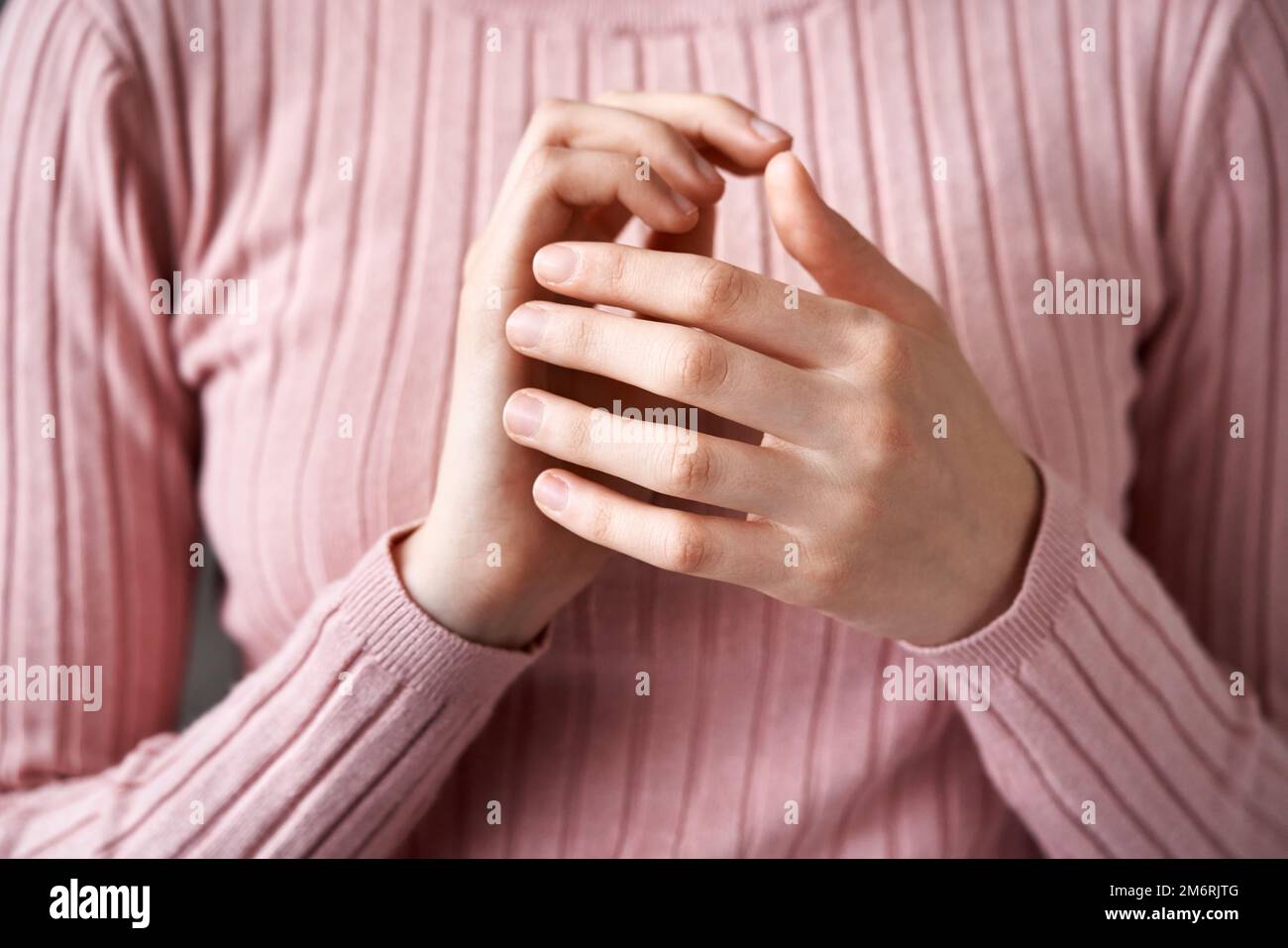 Teenage girl doing EFT or emotional freedom technique - tapping on the karate chop point Stock Photo