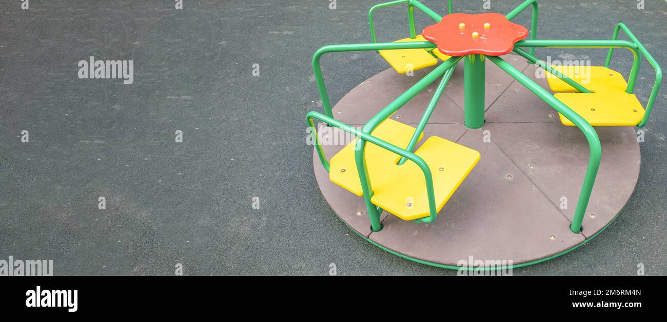 Multi-colored steel round carousel on the playground, a copy of the ...