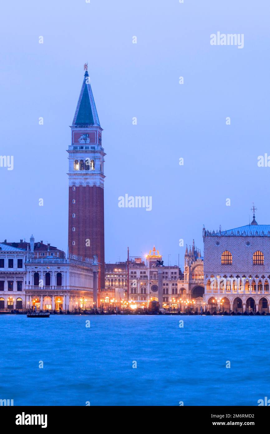 Blick von der Insel San Giogio Maggiore im Abendlicht auf den San Marco Platz mit den historischen Gebaeuden, Venedig, Veneto, Italien Stock Photo