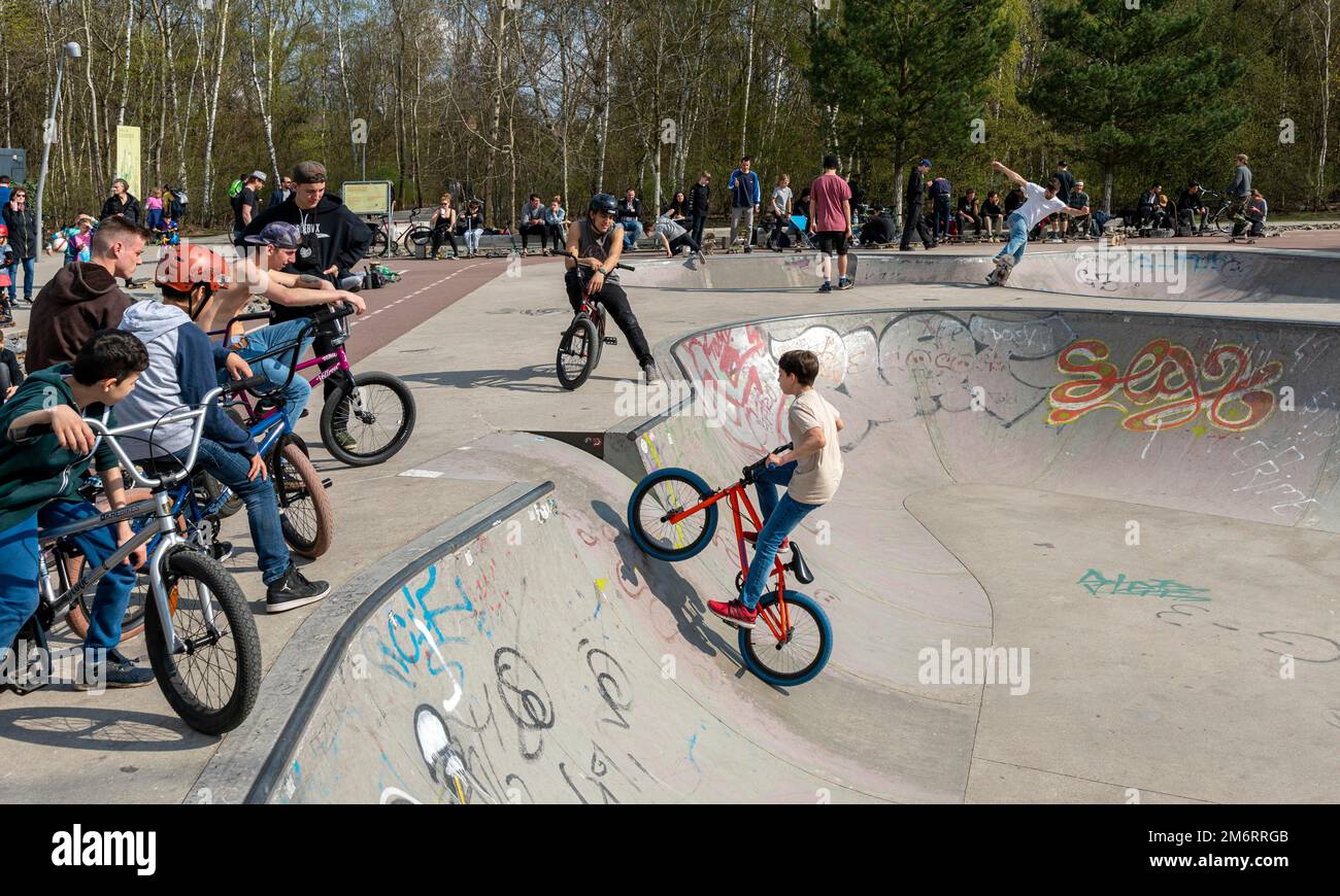 Skateboarders and cyclists at a skate pool in the Park am Gleisdreieck in Berlin-Mitte, Berlin, Germany Stock Photo