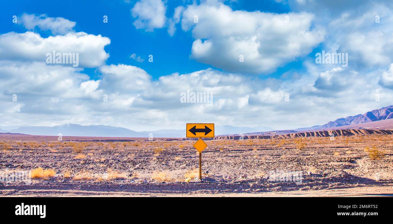 Directional sign in the desert with scenic blue sky and wide horizon. Concept for trip, freedom and transportation. Stock Photo