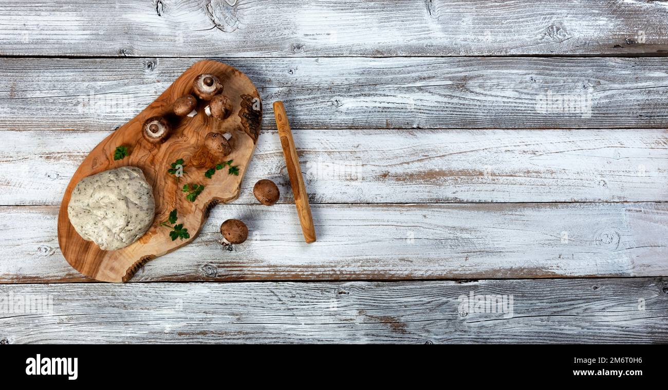 Fresh dough, mushrooms and herbs for making homemade pizza on white wood table background Stock Photo