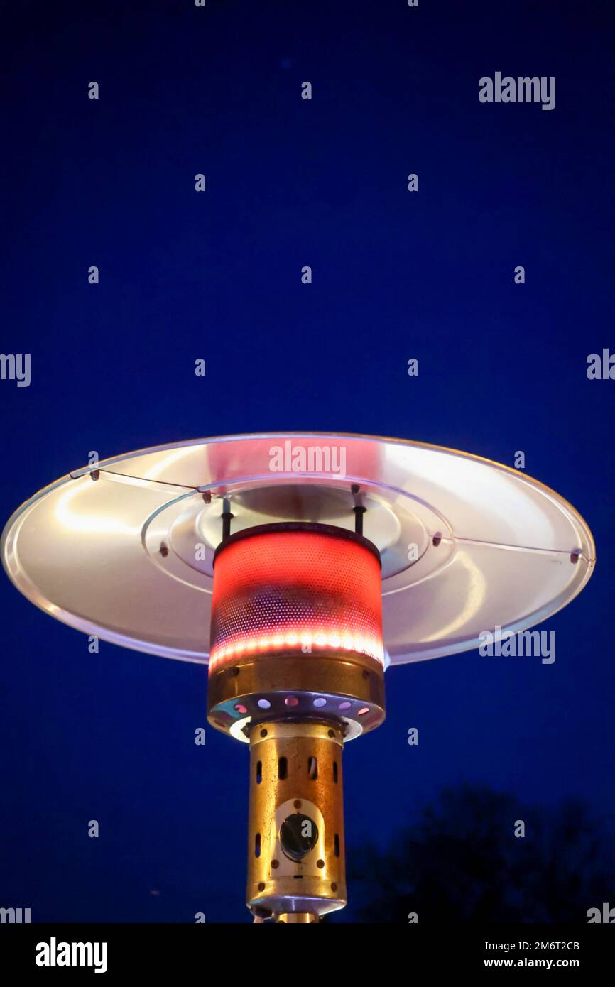 A mushroom heater operated with propane gas in operation Stock Photo