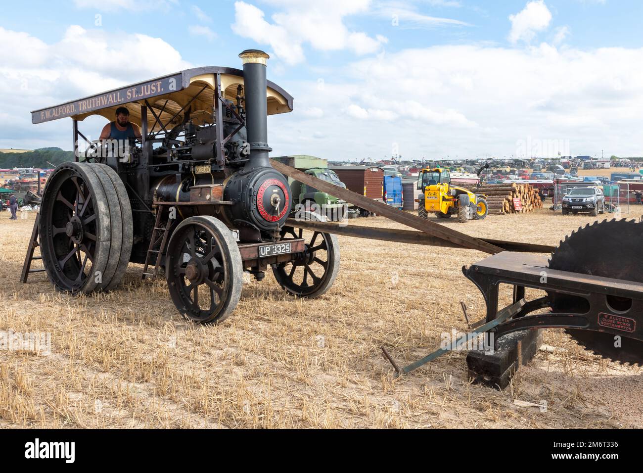 Tarrant Hinton.Dorset.United Kingdom.August 25th 2022.A 1929 Marshall general purpose traction engine called REO is driving an old fashioned circular Stock Photo