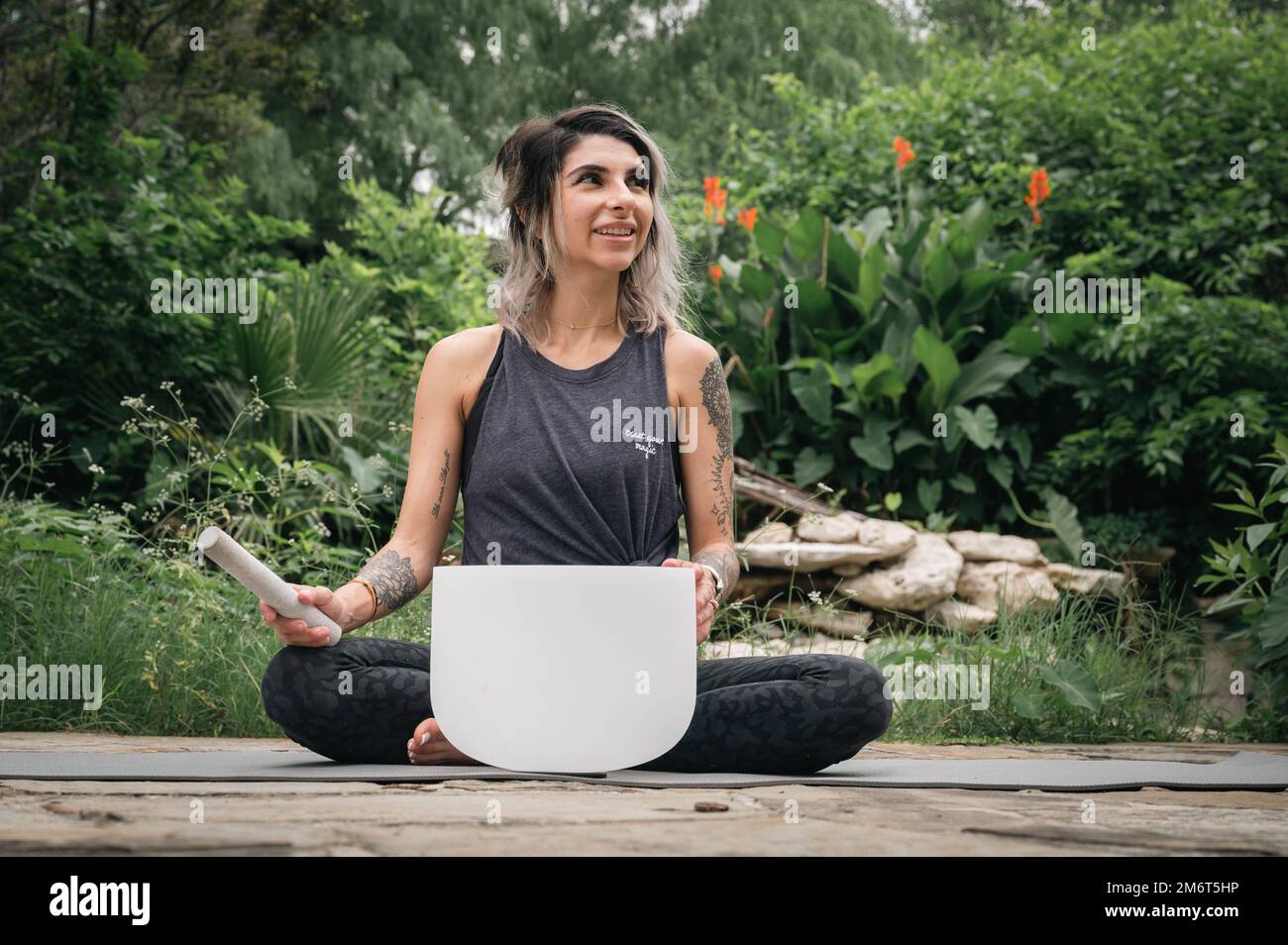 Melissa Aguirre, holistic life coach and stress management specialist, plays a Tibetan sound bowl while practicing yoga at Freedom Park on Brooke Army Medical Center, San Antonio, Texas, Ma4 4, 2022. Tibetan sound bowls are used in holistic practices for the unique tones they produce that can improve the synaptic responses in the brain. Aguirre incorporates them into mindfulness sessions she hosts for local U.S. Army Soldiers recovering from stress injuries and deployment trauma. Stock Photo