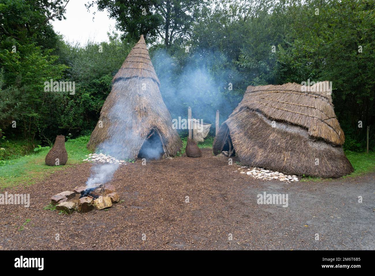 Middle Stone Age campsite with thatched huts and open fire in the Irish