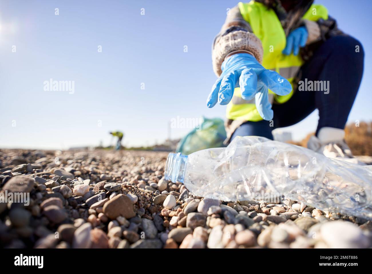 Group of cleanup volunteers cleaning up waste in nature and holding a garbage bag trash Stock Photo