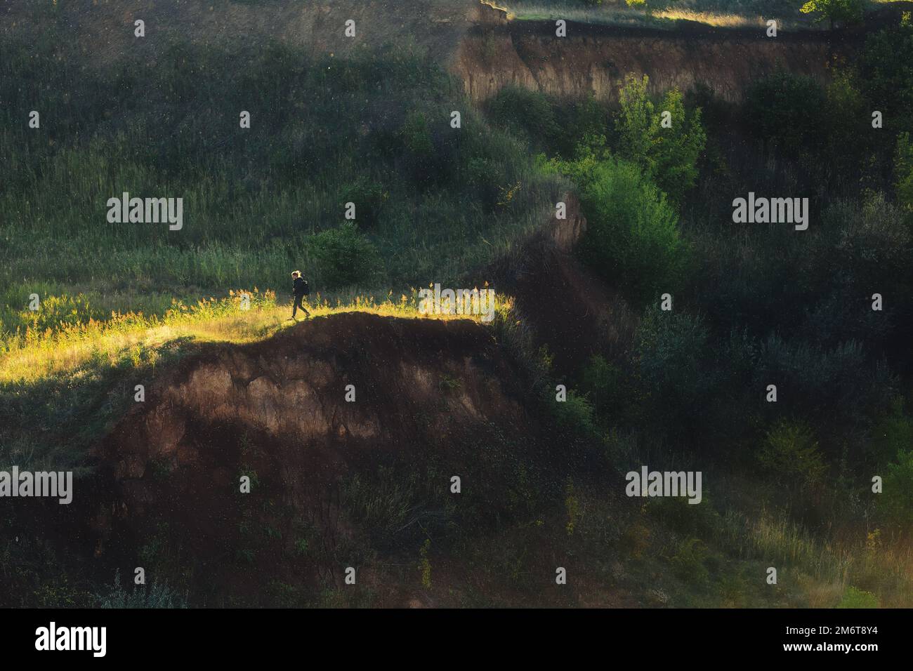 A young woman traveler walk on the edge of collapsed ground zone ...