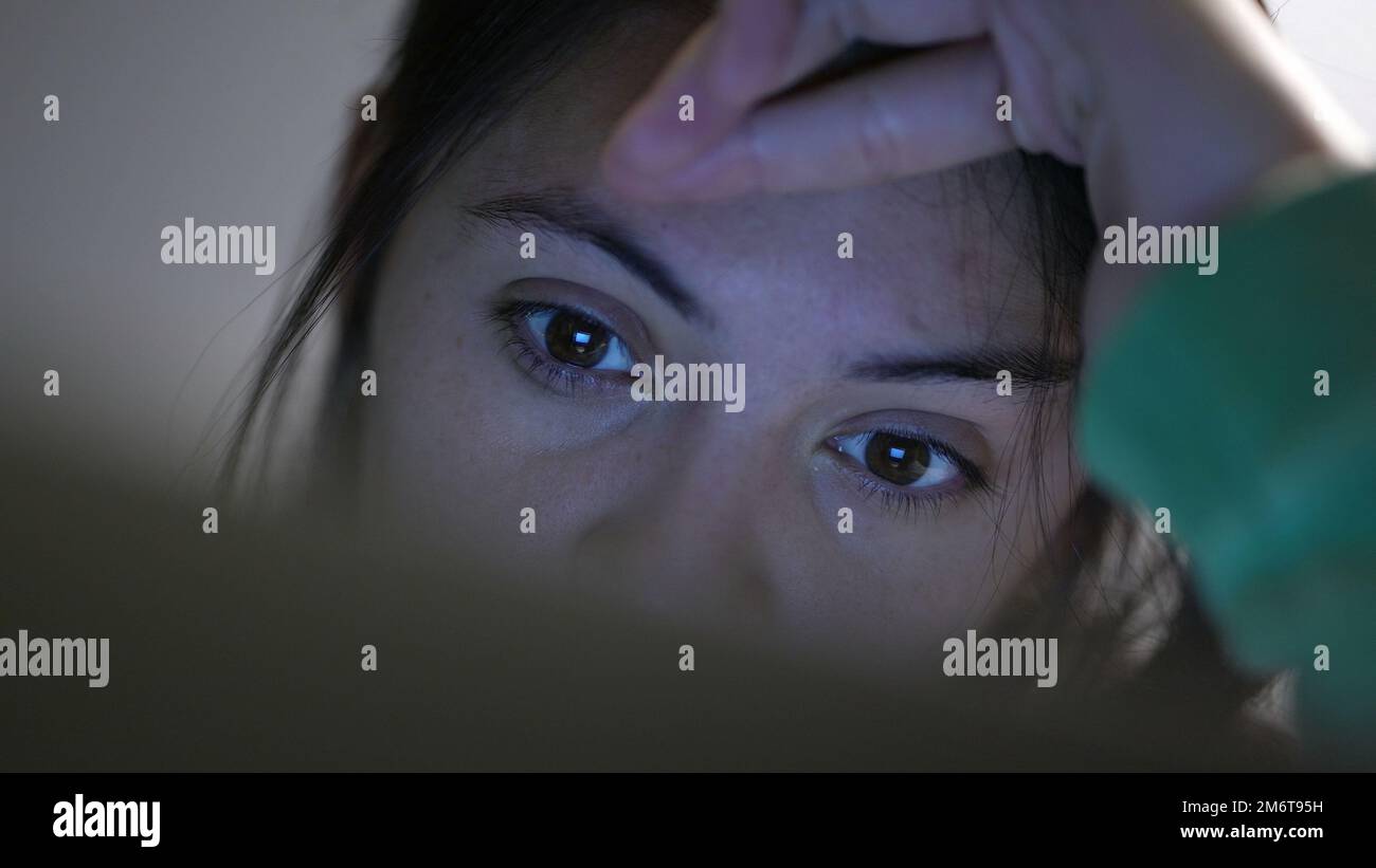 Close-up woman eyes staring at screen at night browsing internet Stock ...