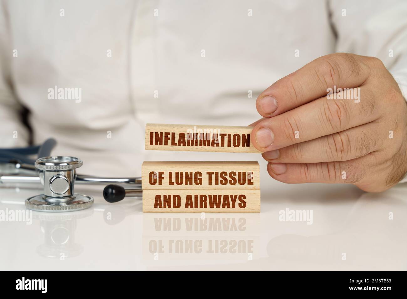 Medical concept. On a white surface, a stethoscope and wooden plates with the inscription - Inflammation of lung tissue and airways Stock Photo