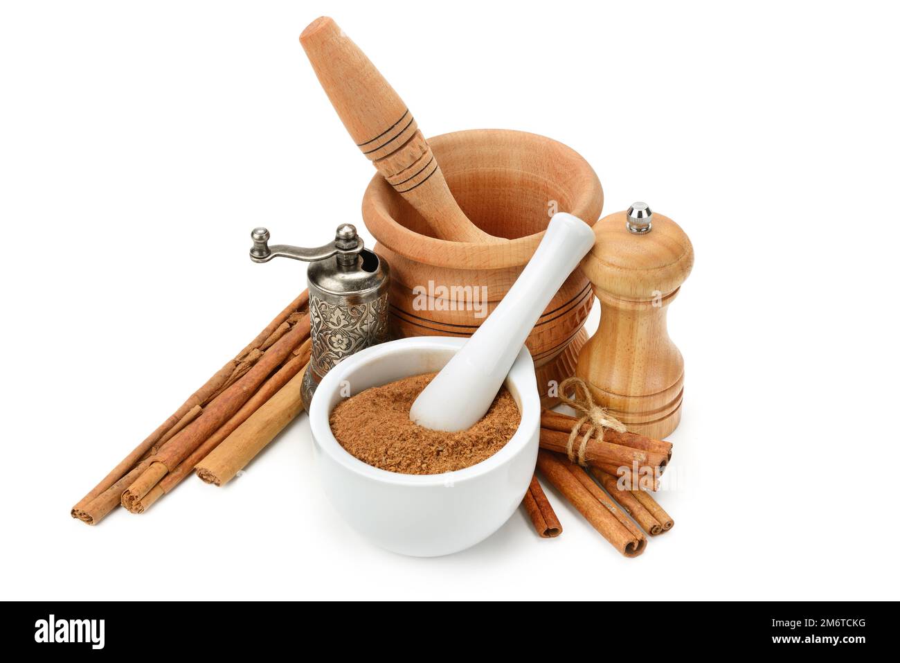 Cinnamon, mortar and pestle, hand grinder isolated on white background