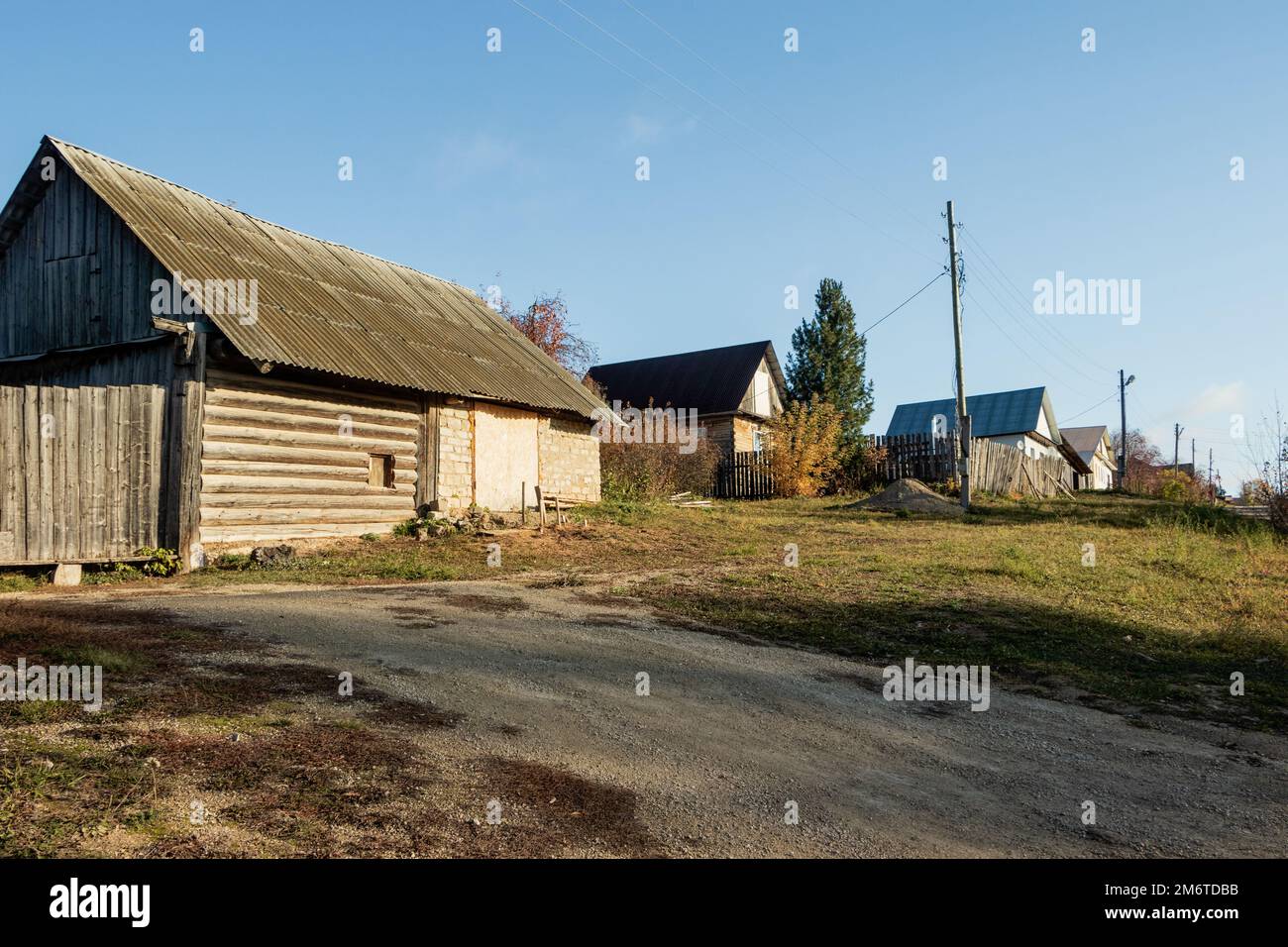 Rural houses are located along the road against the background of the sky. Photo taken in the village of Filippovka, Kurgursky District, Perm Territor Stock Photo