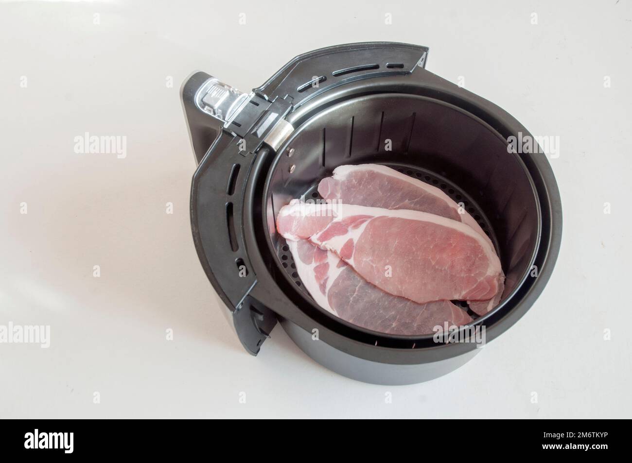 Rashers of Bacon or bacon slices in Air Fryer pan ready to be cooked in