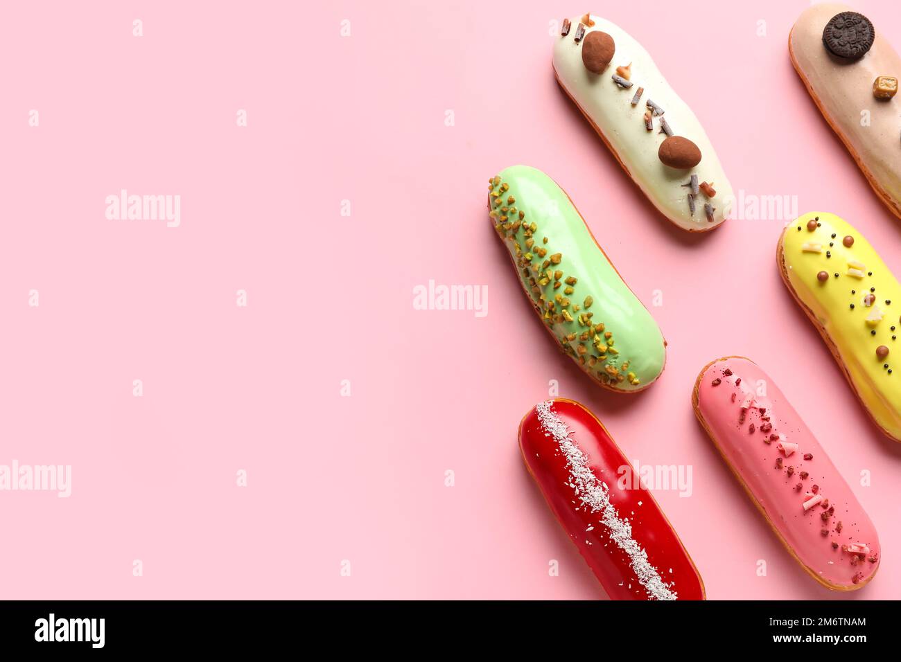 Many delicious glazed eclairs on pink background Stock Photo