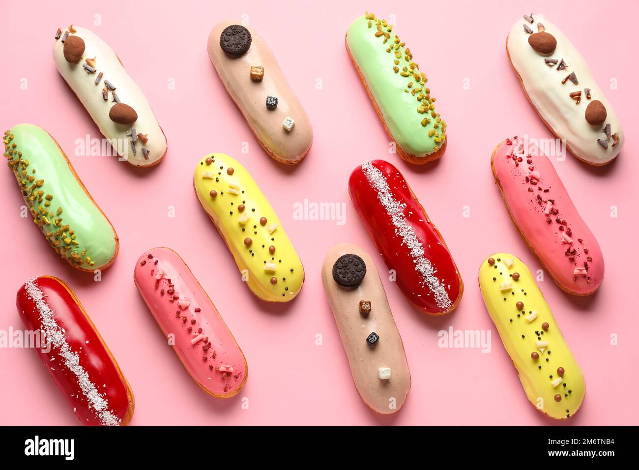 Many delicious glazed eclairs on pink background Stock Photo