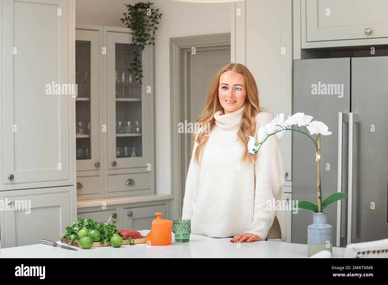 Young woman is preparing in the kitchen. Healthy Food. Salad. Diet. Dieting Concept. Healthy Lifestyle. Cooking At Home. Prepare Food. Stock Photo