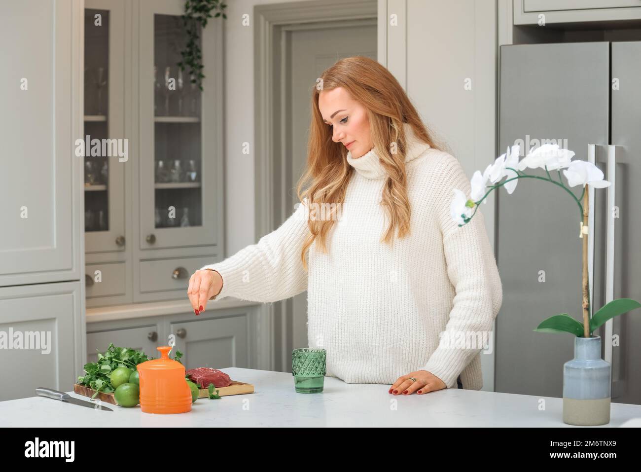 Young woman is preparing in the kitchen. Healthy Food. Salad. Diet. Dieting Concept. Healthy Lifestyle. Cooking At Home. Prepare Food. Stock Photo