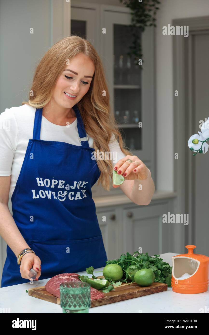 Young woman is preparing in the kitchen. Healthy Food. Salad. Diet. Dieting Concept. Healthy Lifestyle. Cooking At Home. Prepare Food. Cutting Stock Photo