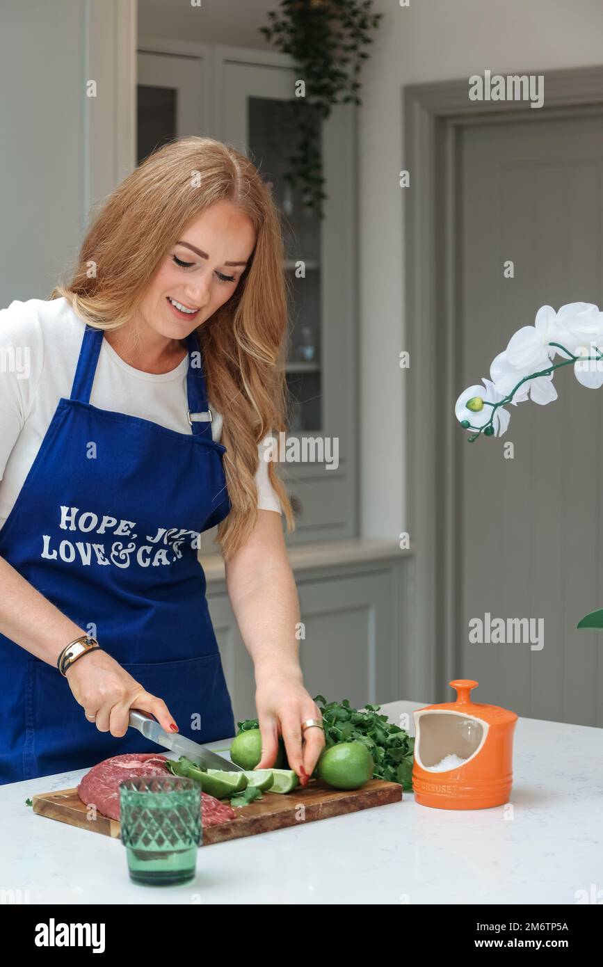 Young woman is preparing in the kitchen. Healthy Food. Salad. Diet. Dieting Concept. Healthy Lifestyle. Cooking At Home. Prepare Food. Cutting Stock Photo