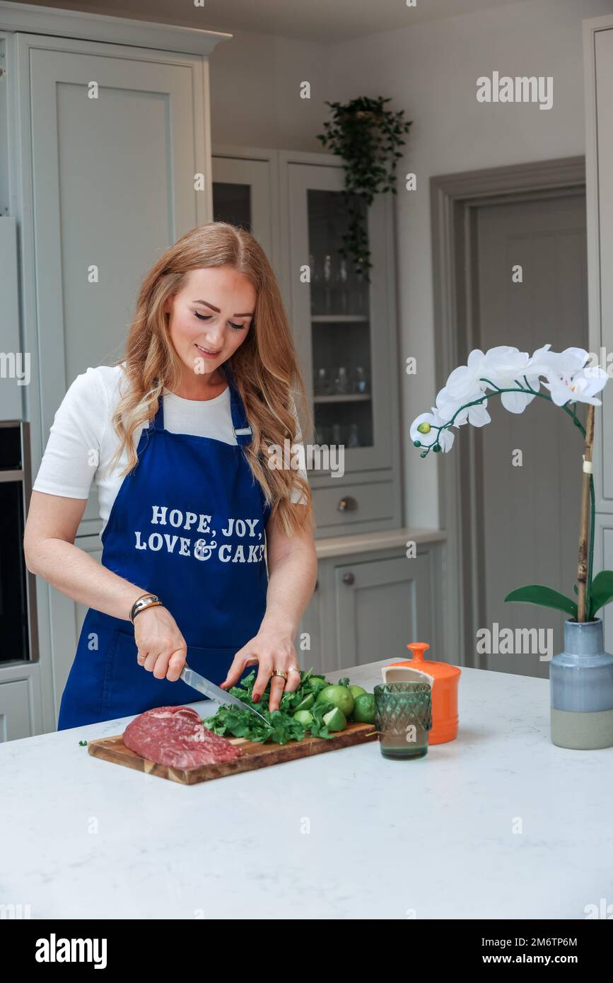 Young woman is preparing in the kitchen. Healthy Food. Salad. Diet. Dieting Concept. Healthy Lifestyle. Cooking At Home. Prepare Food. Stock Photo