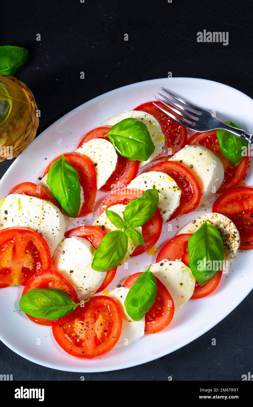 Tomato with mozzarella and basil Stock Photo - Alamy