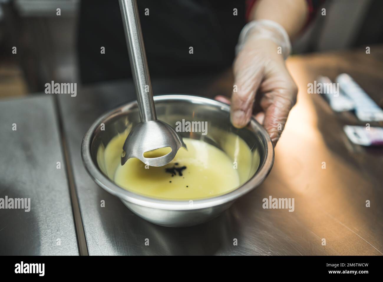 Close-up of a pastry chef mixing icing with food coloring with a hand blender. High angle shot. High quality photo Stock Photo