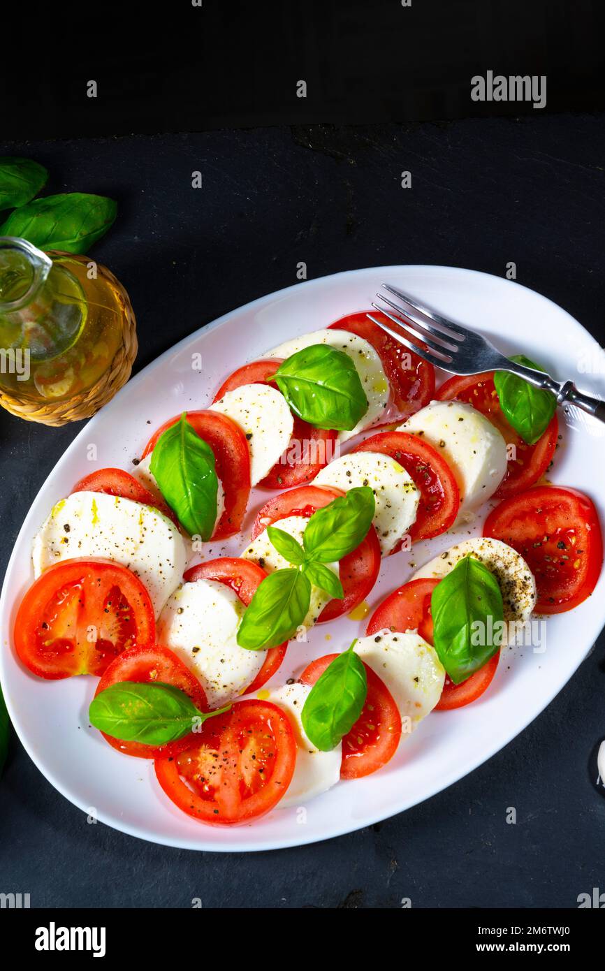 Tomato with mozzarella and basil Stock Photo - Alamy