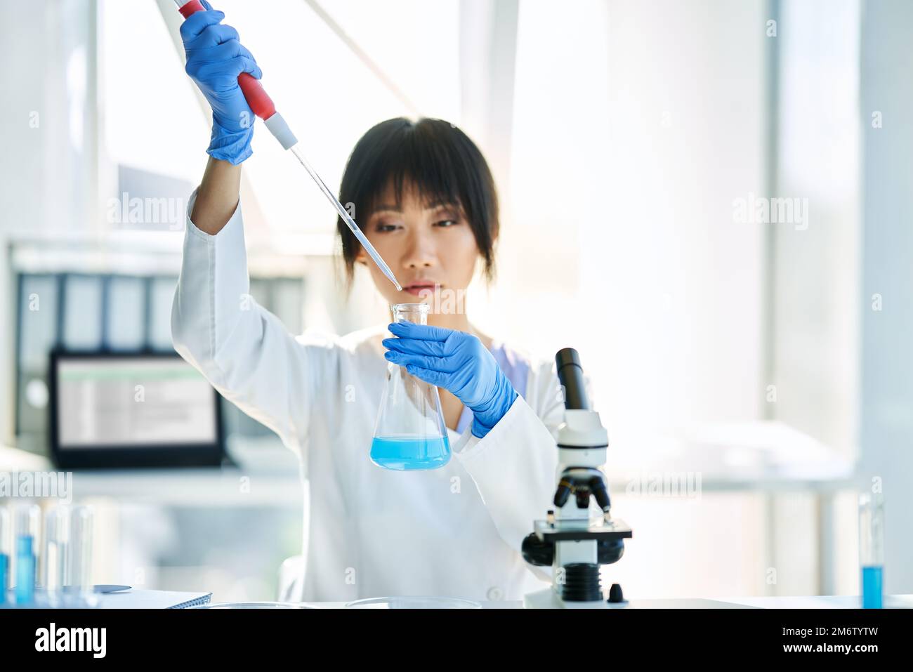 Asian scientist working in big modern laboratory doing some research Stock Photo