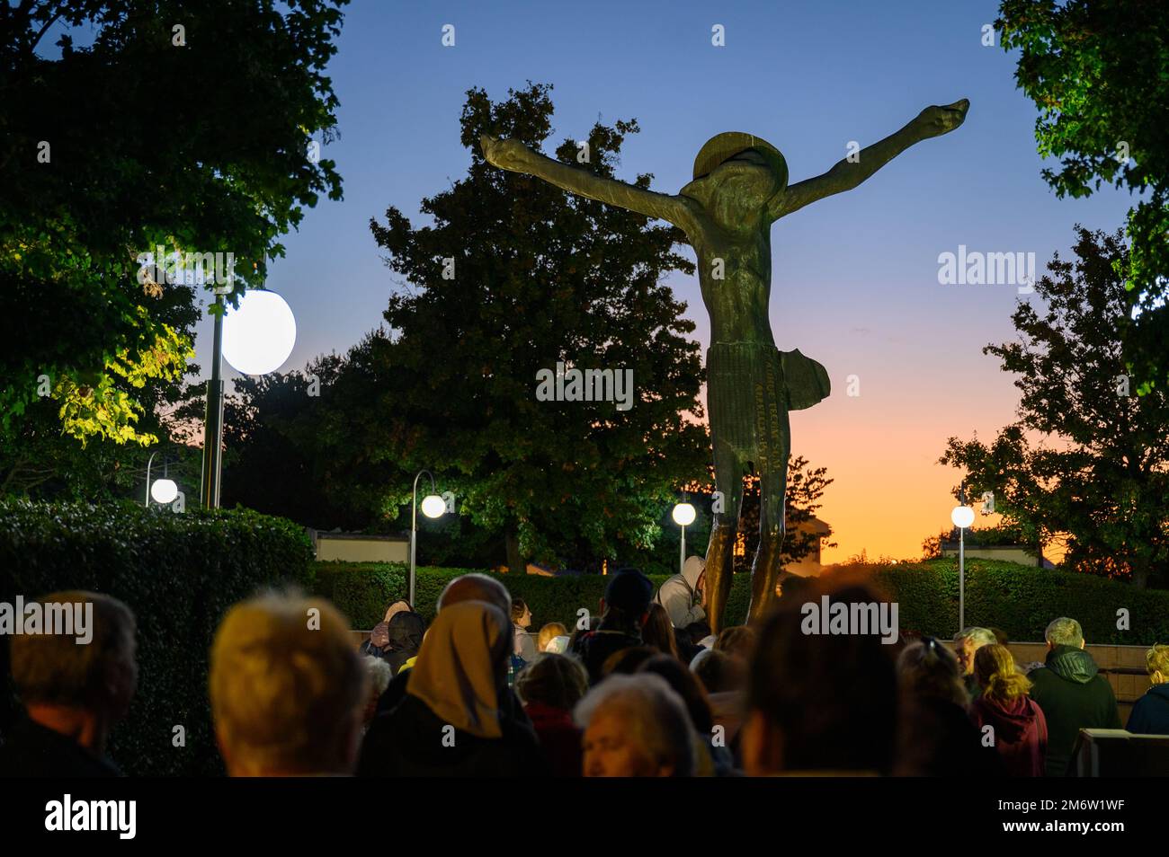 A queue of pilgrims venerating one by one the weeping statue of the