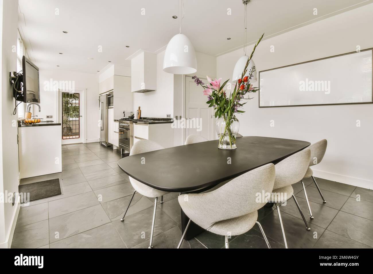 a kitchen and dining area in a house with white walls grey