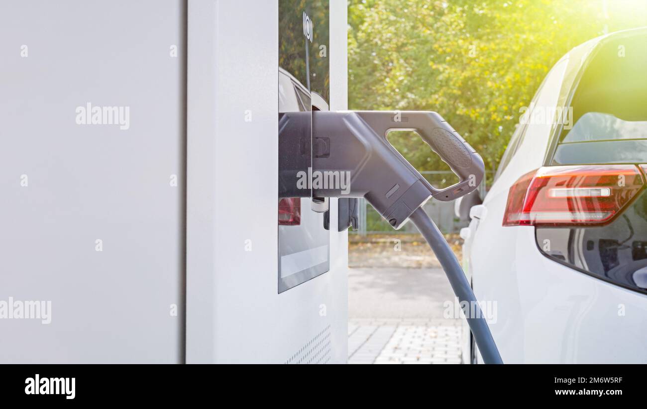 Environment friendly electric car at charging station Stock Photo - Alamy