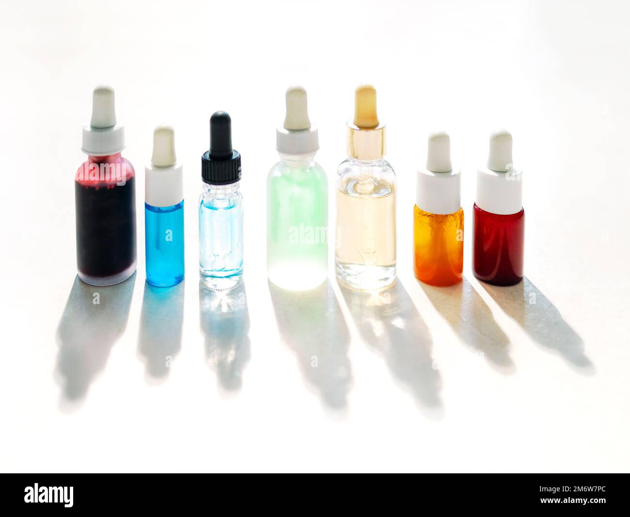 Serum with collagen and peptides in colorful glass bottles on light background Stock Photo