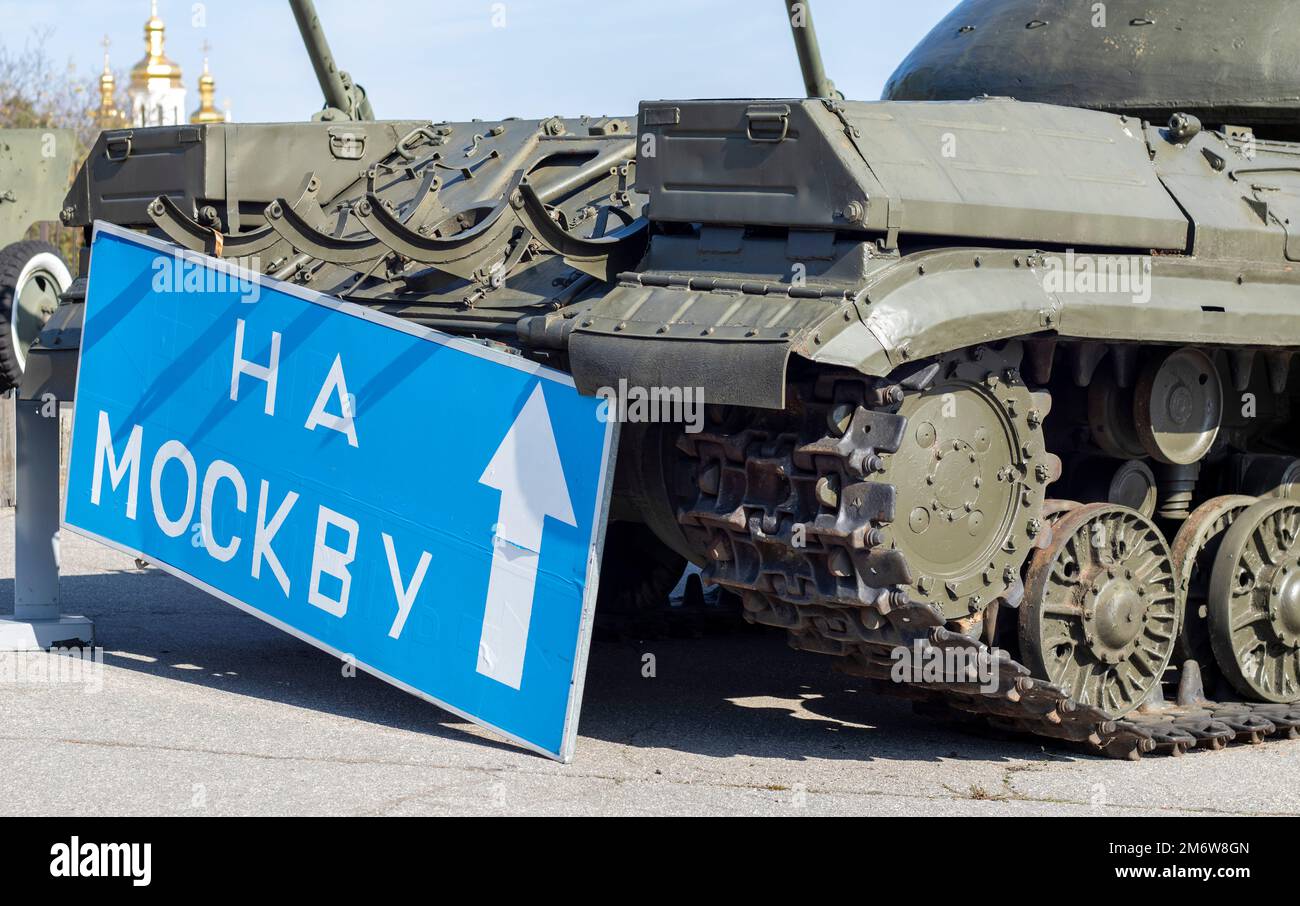 Blue road sign with white letters near the tank, on the territory of the National Museum of the History of Ukraine. Russia's war Stock Photo