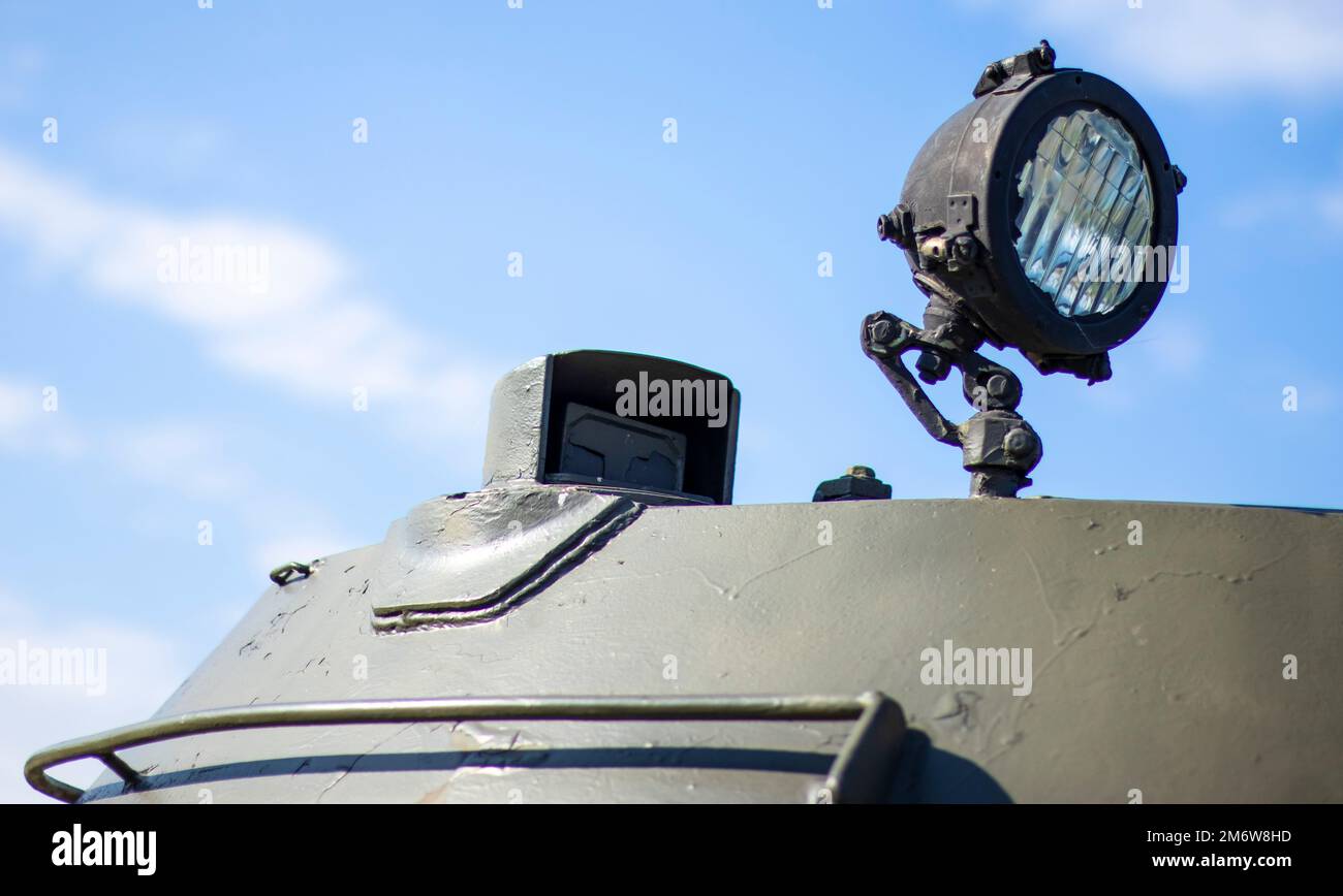 Front headlight of a Soviet battle tank. Very bright searchlight on the tank turret, close-up. Armored infantry fighting vehicle Stock Photo