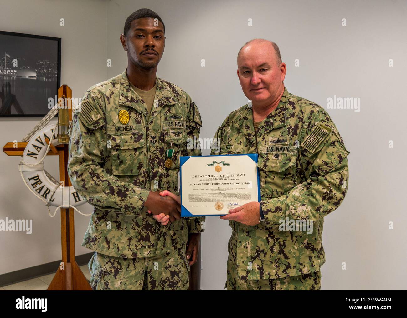 220506-N-KN989-1001 JOINT BASE PEARL HARBOR-HICKAM, Hawaii (May 6, 2022) Rear Adm. Timothy Kott, Commander, Navy Region Hawaii presents Master-at-Arms 1st Class Lamar McNeal with the Navy and Marine Corps Commendation Medal after being selected as Commander Navy Region Hawaii’s 2021 Shore Sailor of the Year. Commander Navy Region Hawaii is the regional coordinator for all shore-based naval personnel and shore activities in Hawaii - as well as the Navy’s representative to the Hawaii community. Stock Photo