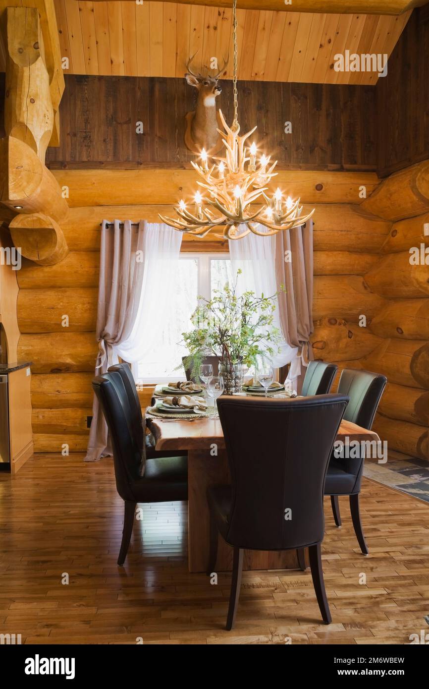 Natural wood dining table and brown leather chairs in dining room