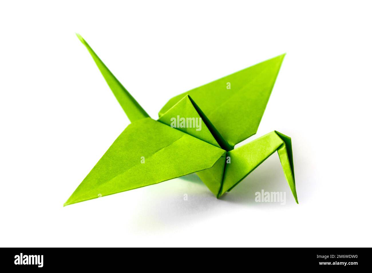 Green paper crane origami isolated on a white background Stock Photo