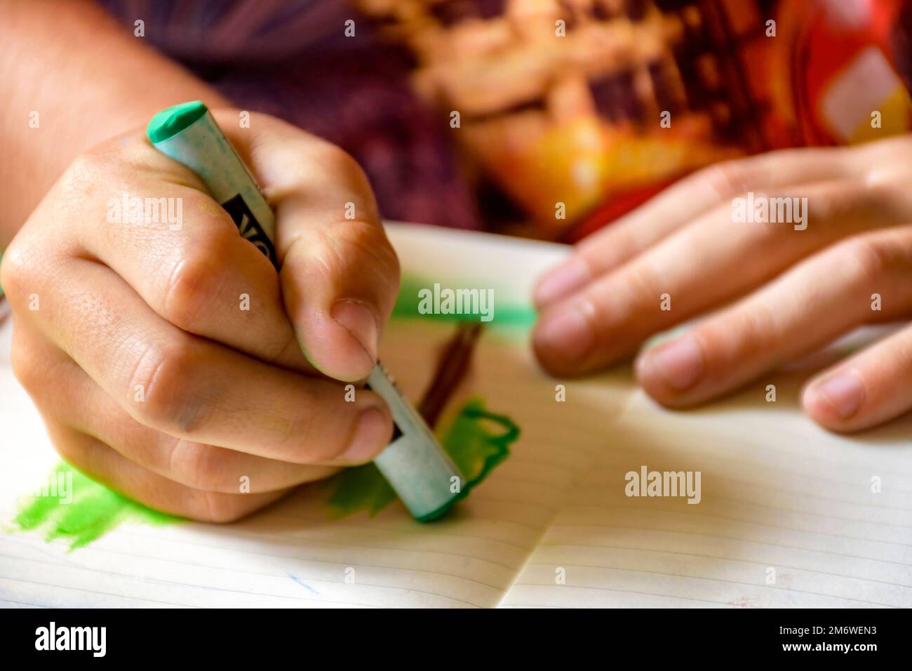Young child hands drawing with crayon on a sheet of paper Stock Photo