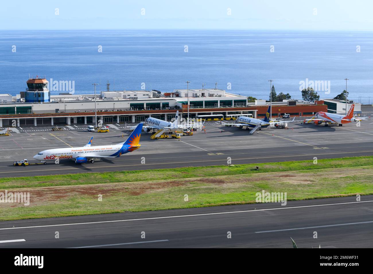 Funchal Airport passengers terminal exterior view. Madeira Airport ramp busy with multiple aircraft. Cristiano Ronaldo International Airport terminal. Stock Photo