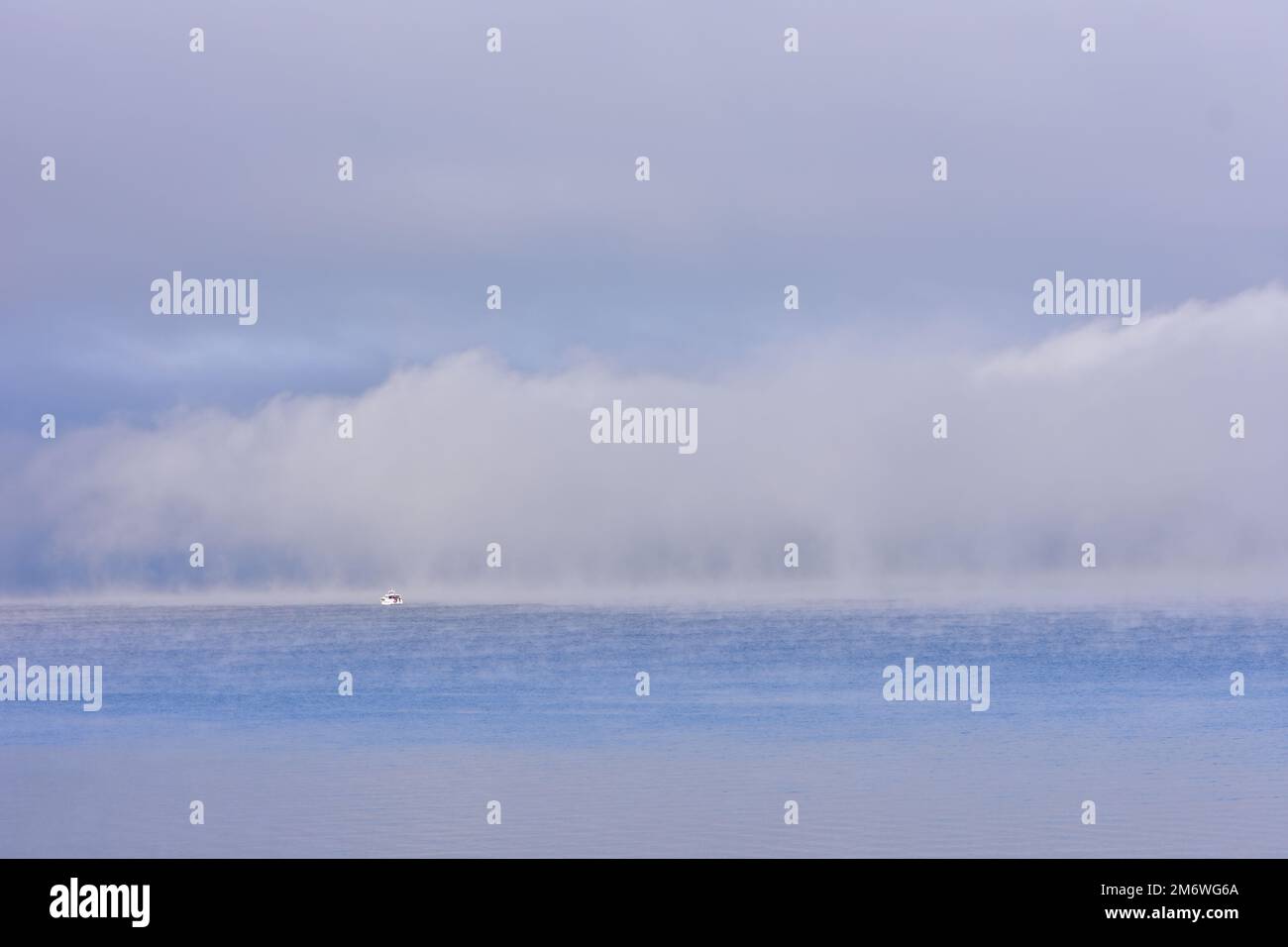 Boat at the edge of dense fog layer on Lake Taupo. Location: Taupo New Zealand Stock Photo