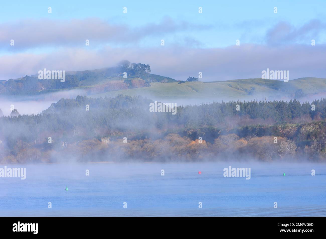 Morning fog covering water surface and shores around Lake Taupo. Location: Taupo New Zealand Stock Photo